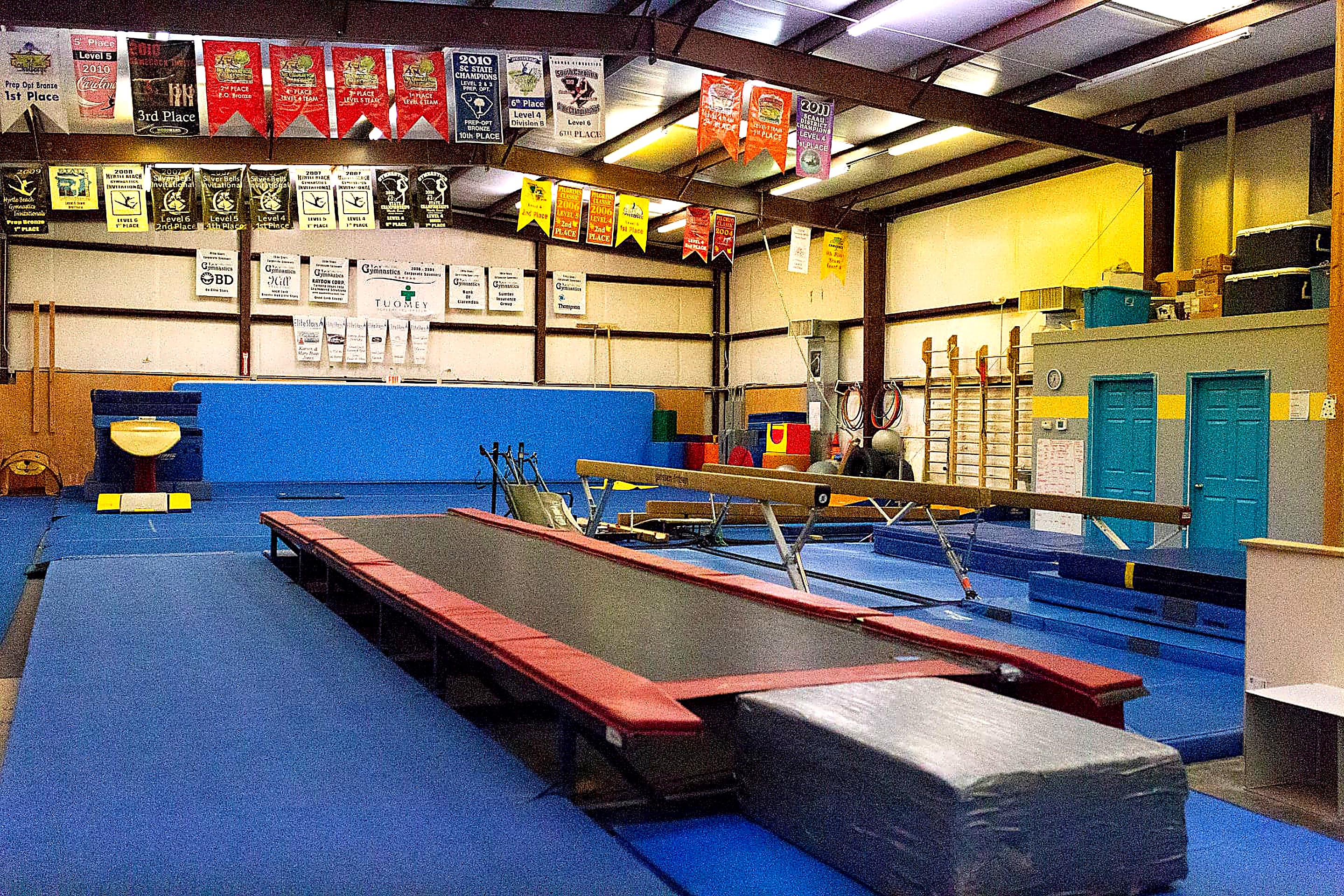 Vault runway, beams and spring floor under team banners