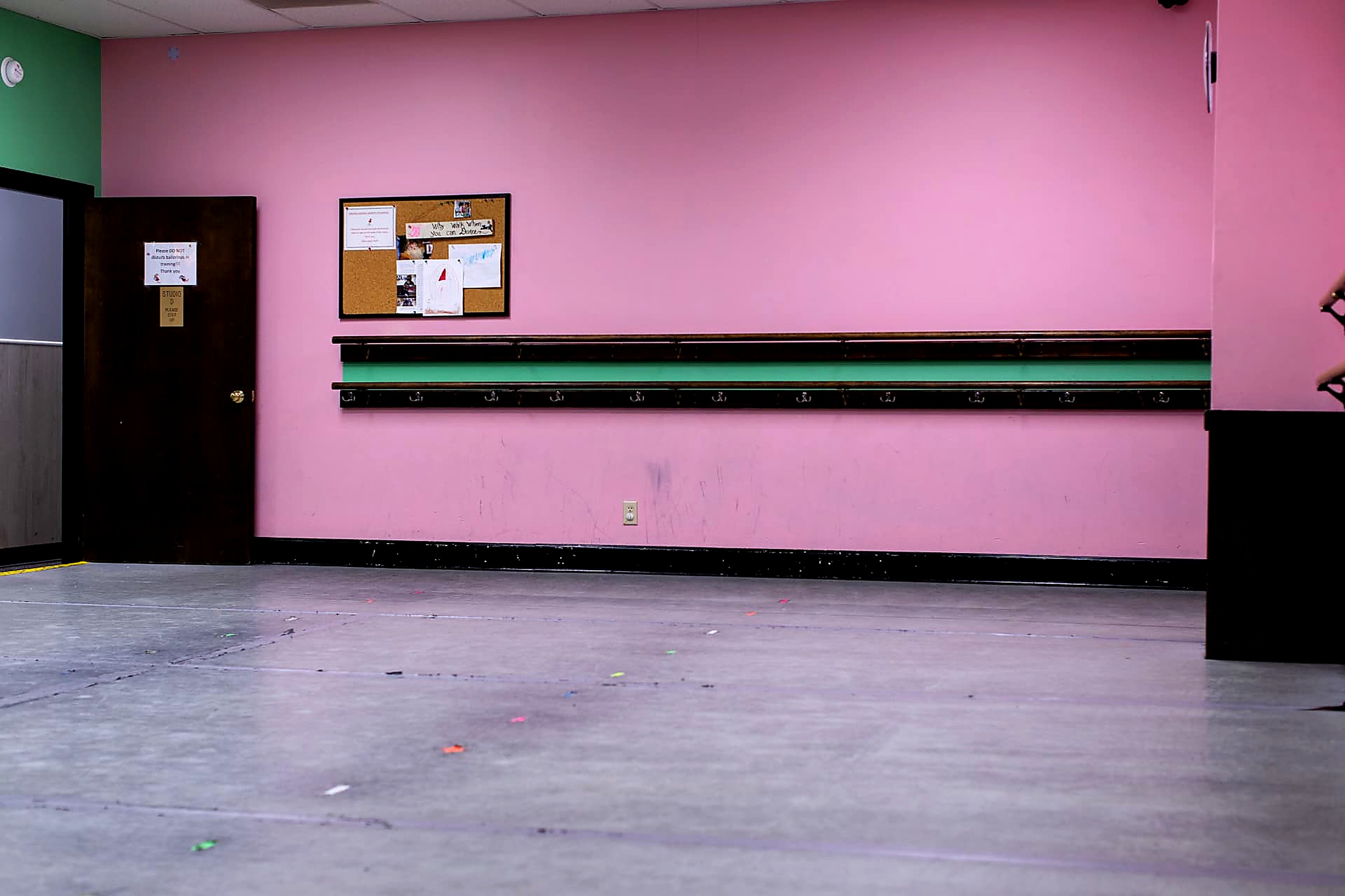 Pink studio with barres, bulletin board and marked floor