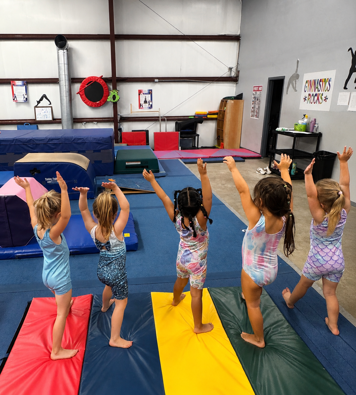 Preschool gymnasts raising their arms during class at Miss Libby's