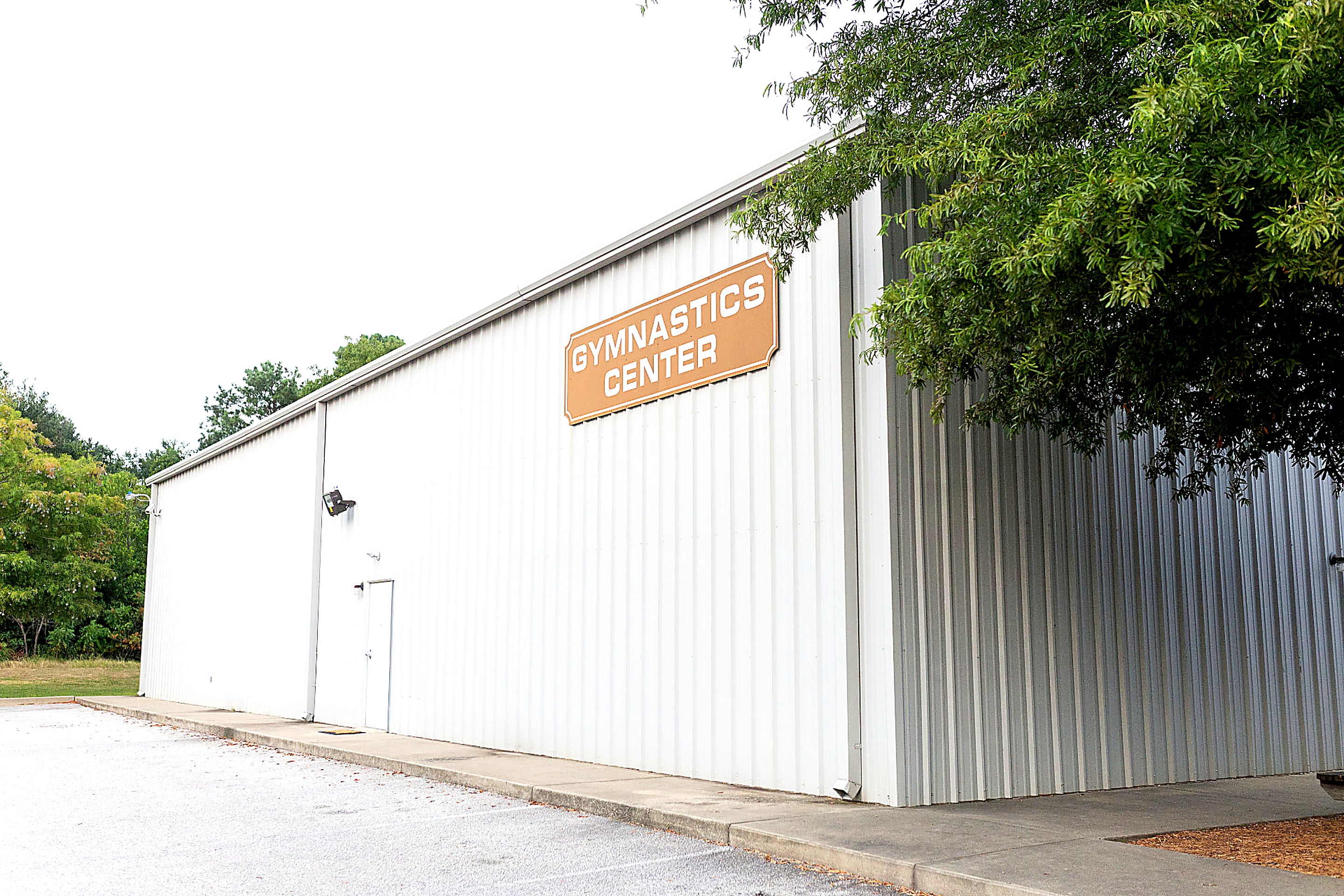 Close view of the Gymnastics Center sign on the metal building