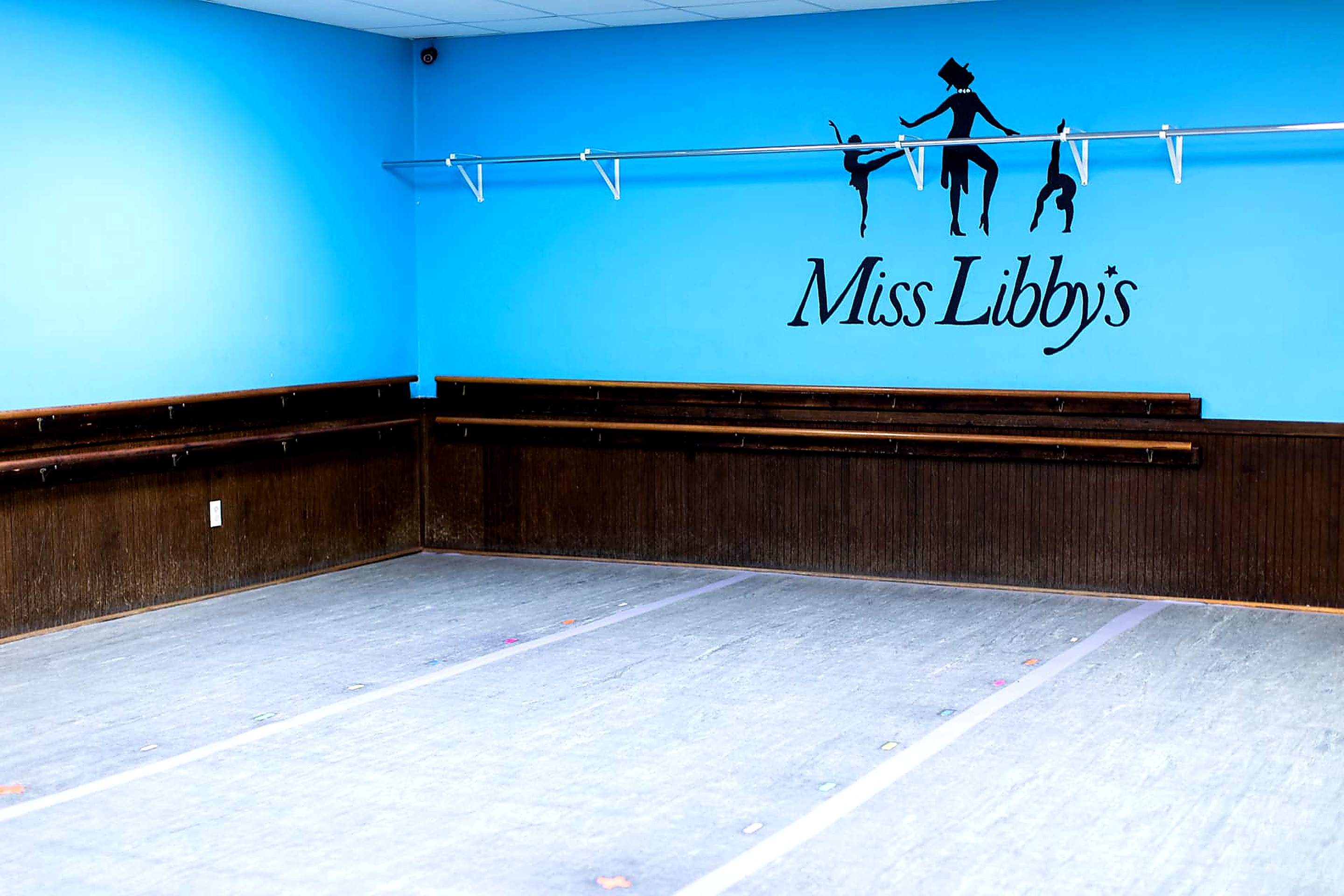Blue studio with barre and the Miss Libby's dancer silhouette logo