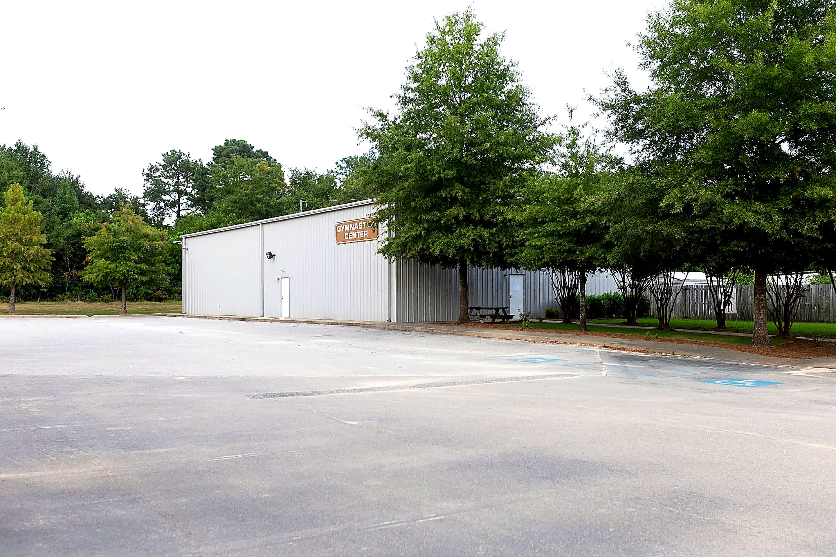 Exterior of the Gymnastics Center building with its sign, framed by trees