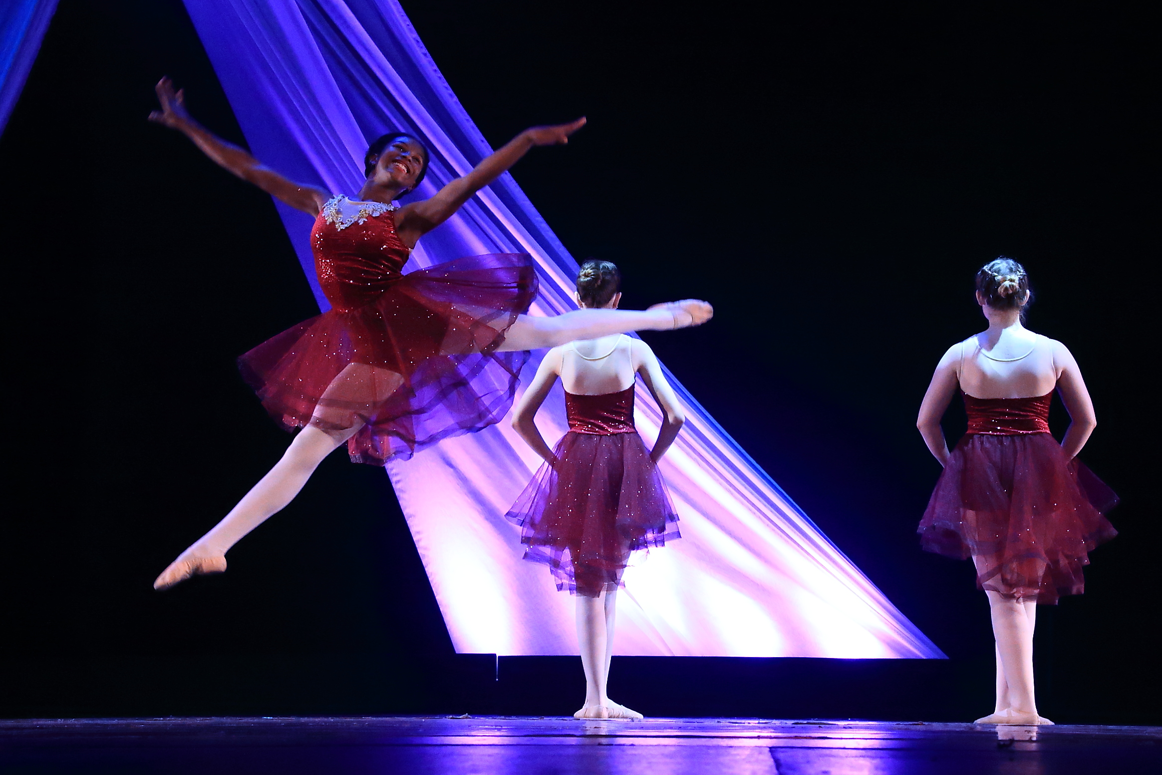 Ballet dancer leaping on stage in a Miss Libby's recital